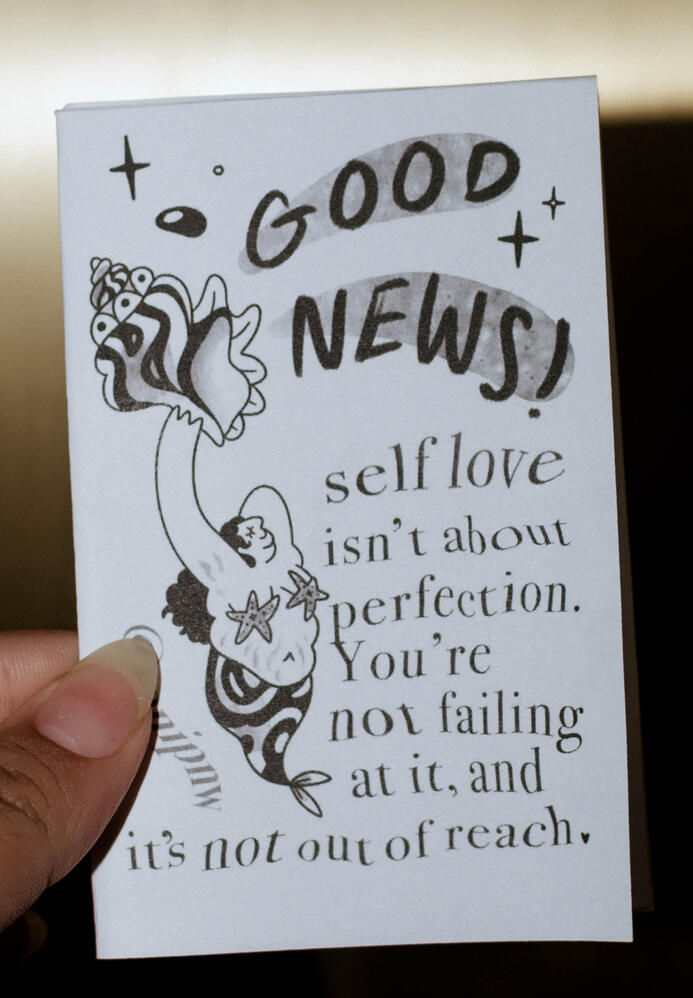 Untitled A photo of a zine titled "Good News!" smaller text says "self love isn't about perfection. You're not failing at it, and it's not out of reach."